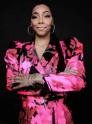An image of a Black woman in a pink blazer
