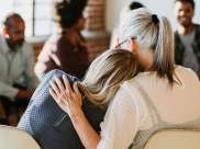 women hugging during epilepsy and suicide support group